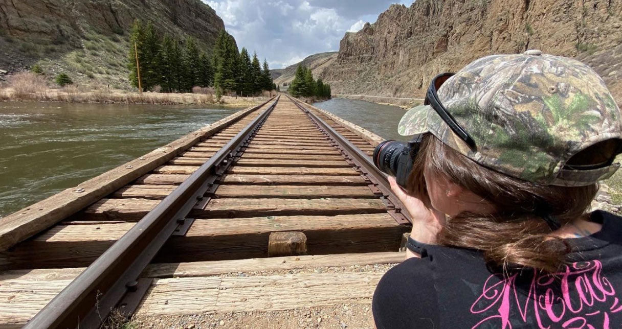 Woman on train tracks taking a photo